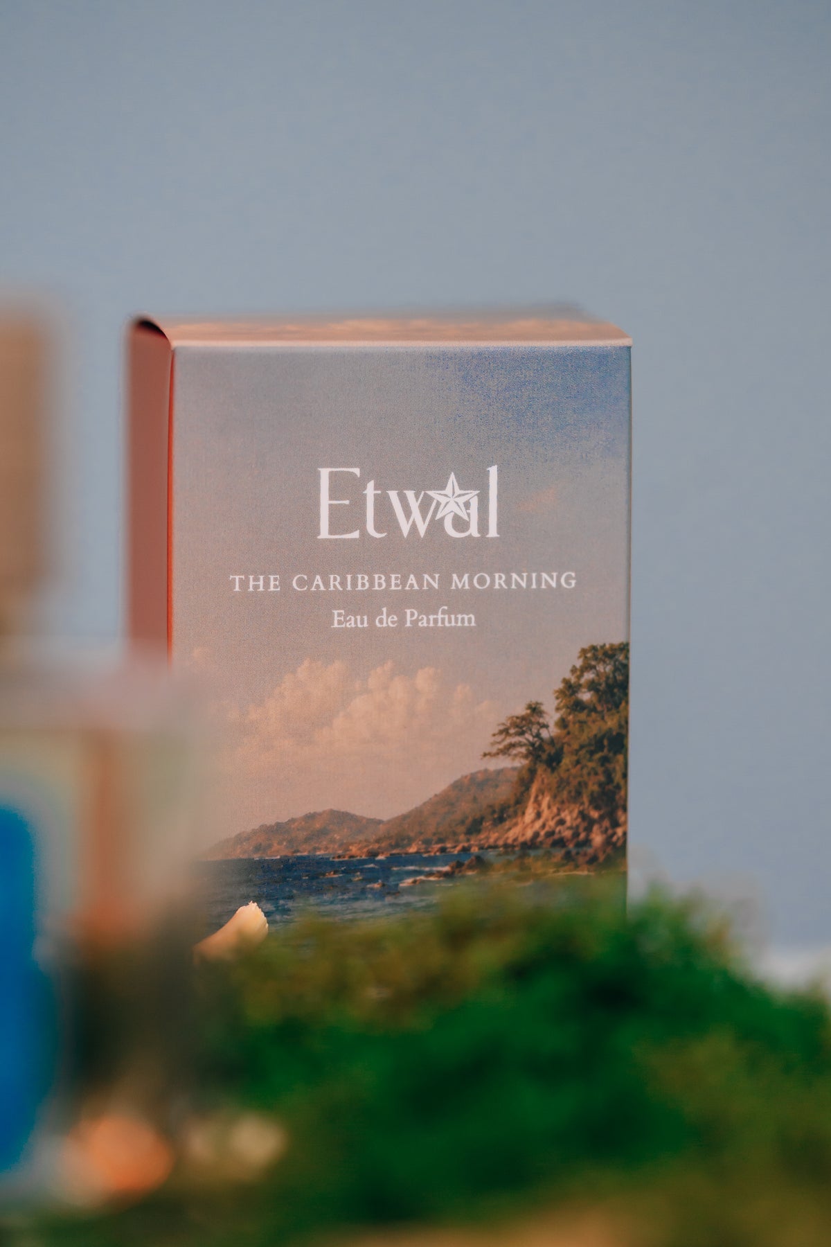 The Caribbean Morning perfume bottle displayed on a wood pedestal